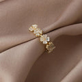 Adjustable gold ring with white blossoms and zirconia