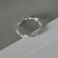 Braided silver band with intricate design