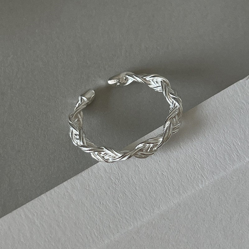 Braided silver band with intricate design