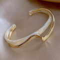 Elegant open bracelet crafted from white enamel and gold.