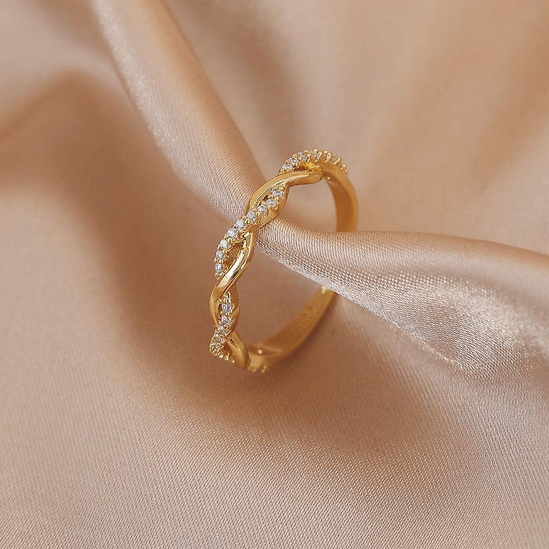 Adjustable ring with braided zirconia stones in gold.