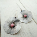Vintage earrings featuring silver petals and a red gemstone.
